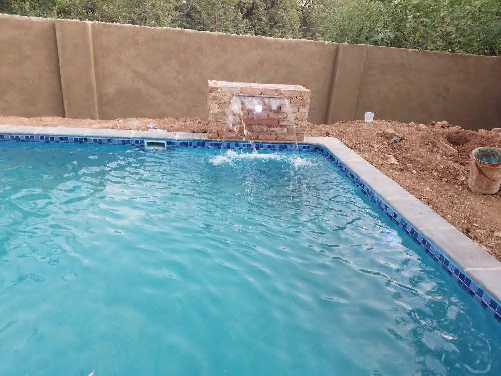 Swimming pool with a brick water feature