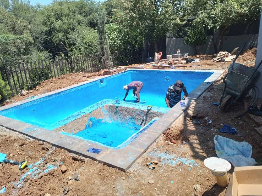 Workers plastering a new swimming pool